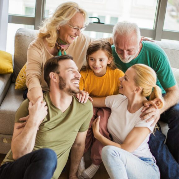 stock photo of a family laughing with each other while seated on a couch