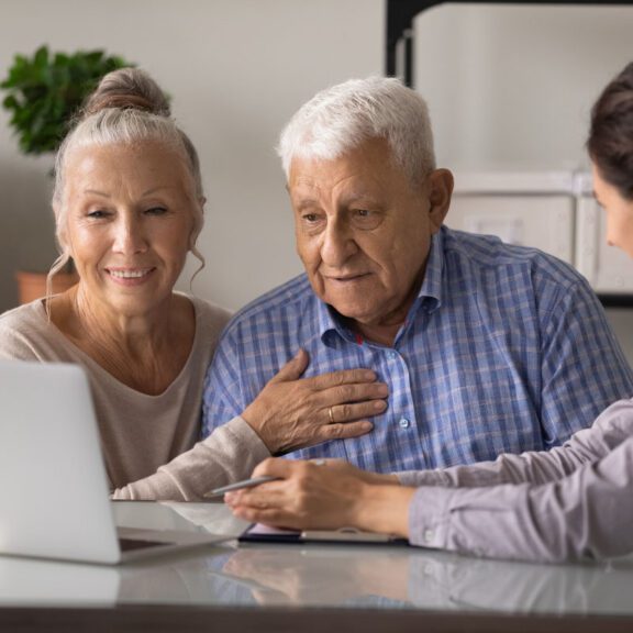 stock photo of an older couple looking at a computer with a woman pointing to the screen