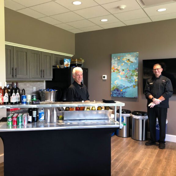 photo of bar tenders standing at a stocked bar
