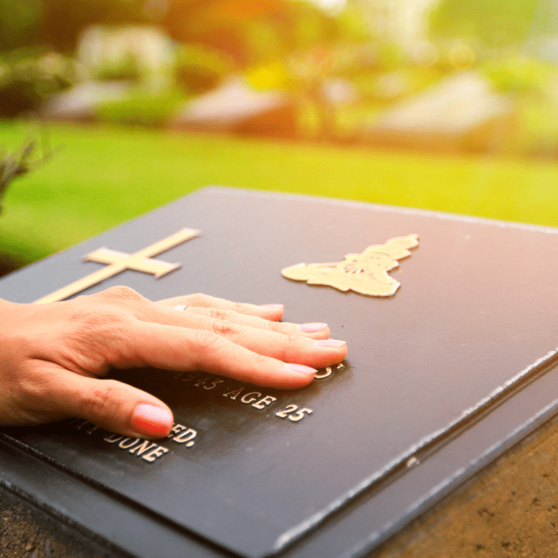photo of a hand on a permanent memorial plaque