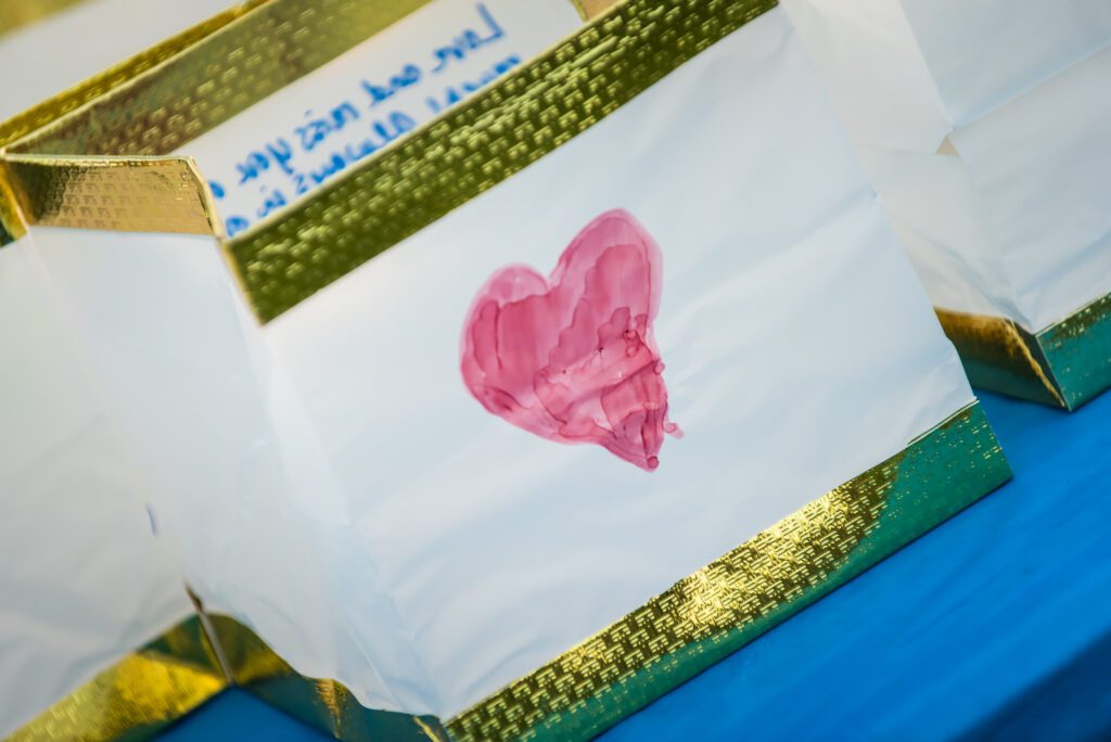 Close up image of a white paper memory lantern with a red heart drawn on it