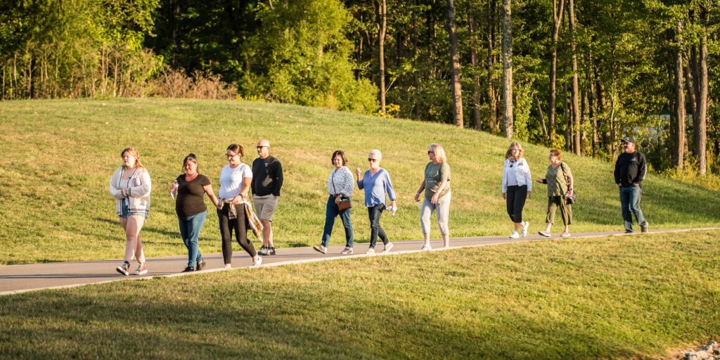 Photo of a group of people walking in a line down the side of a road