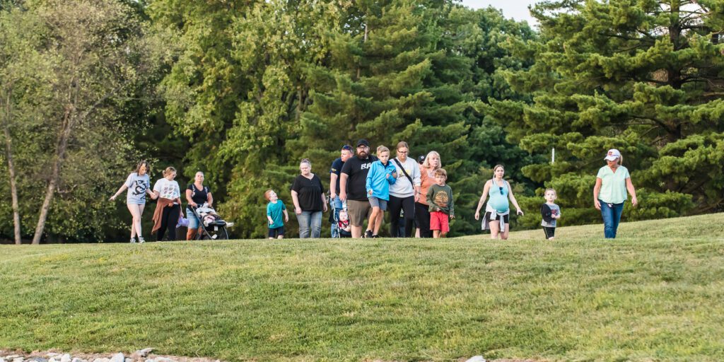 Photo of a large group of people standing in the grass