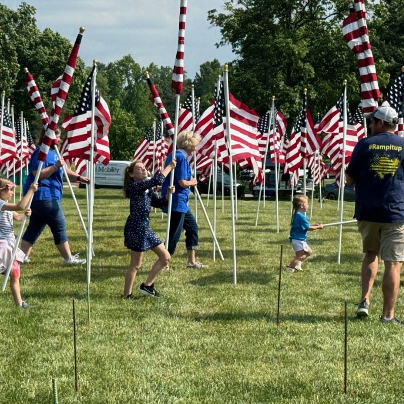 Voluntees putting American flags into the ground for Memorial Day
