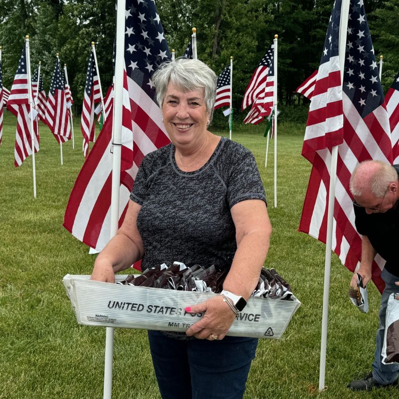 Volunteers placing American flags in the ground for Memorial Day
