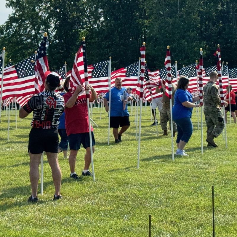 Volunteers placing American flags in the ground for Memorial Day