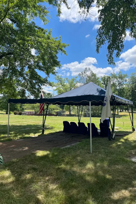 Beautiful cemetery image with pop up canopy over grave with American